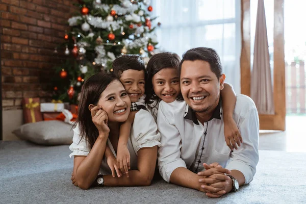 Asiatische Familie liegt auf dem Boden und lächelt in die Kamera — Stockfoto