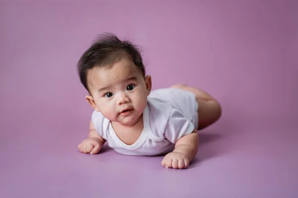 Bebê deitado em sua barriga no estúdio — Fotografia de Stock