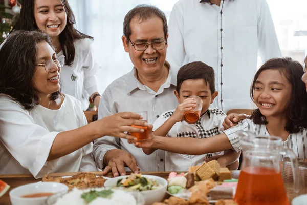 Família aplaudindo durante o almoço juntos em casa — Fotografia de Stock