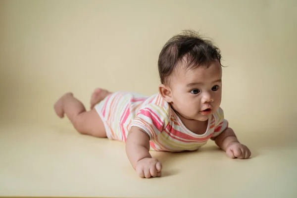 Baby laying on her belly in studio — Stock Photo, Image