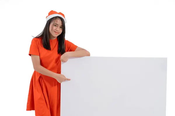 Niño con sombrero de santa claus sonriendo sosteniendo tablero en blanco — Foto de Stock