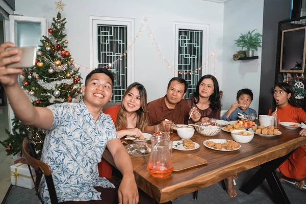 Familia tomando selfie mientras disfruta de la cena víspera de Navidad — Foto de Stock