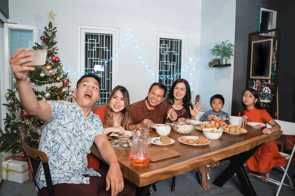 Familia tomando selfie mientras disfruta de la cena víspera de Navidad —  Fotos de Stock