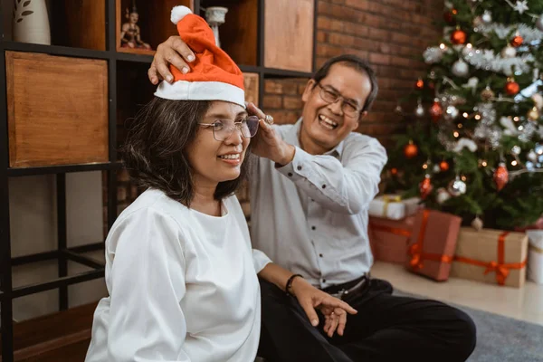 Familie setzt Weihnachtsmütze bei Weihnachtsfeier auf — Stockfoto