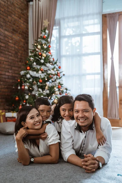 Asiatische Familie liegt auf dem Boden und lächelt in die Kamera — Stockfoto