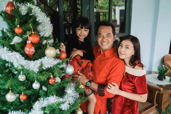 Família e filha pendurado decoração árvore de Natal — Fotografia de Stock