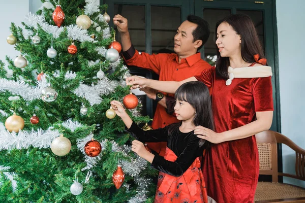 Rodzina i córka wiszące dekorowanie choinki — Zdjęcie stockowe
