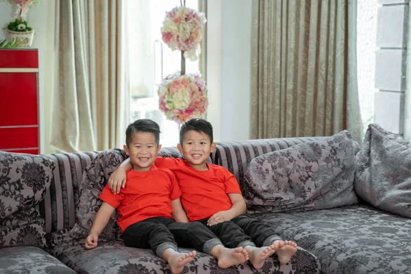 Twee aziatische jongens glimlachen het dragen van rode shirts — Stockfoto