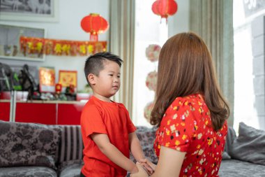 Asyalı anne el ele tutuşup oğlunun yeni yılı kutlamasını istiyor.