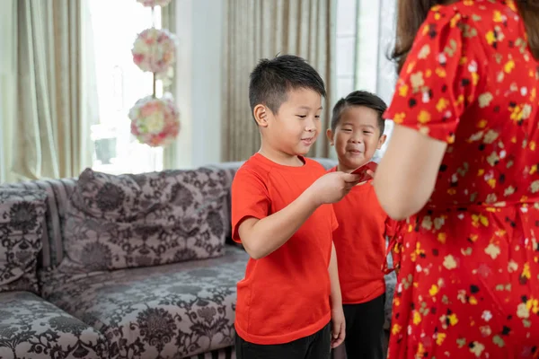 Asian chinese mother give ang pao to her sons