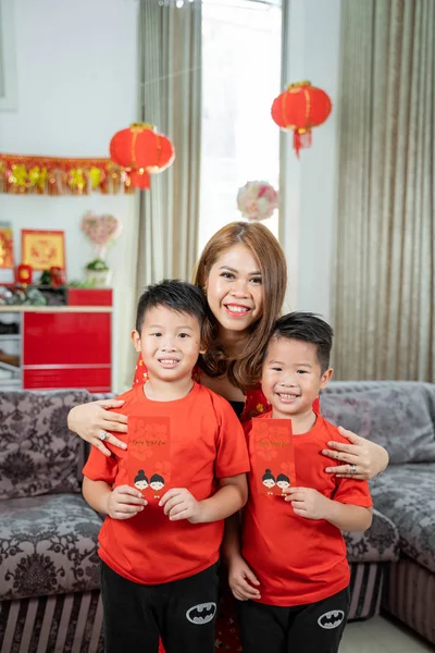 Asian chinese mother with two son holding ang pao smiling looking at camera — ストック写真