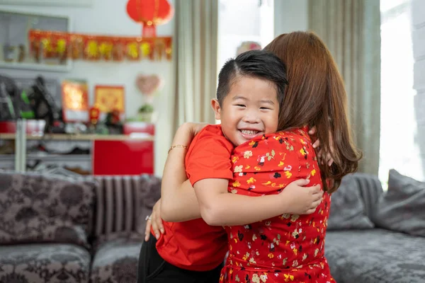 Having fun asian little boy embracing with mother