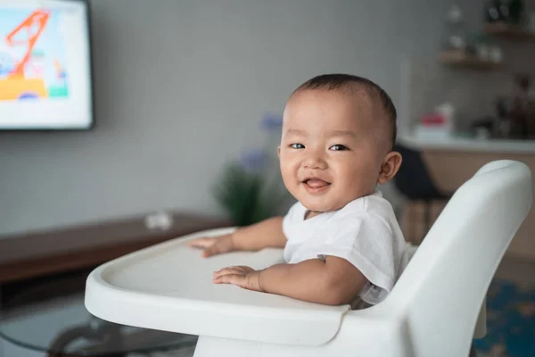 Asiático bebé niño sentado en alto silla —  Fotos de Stock