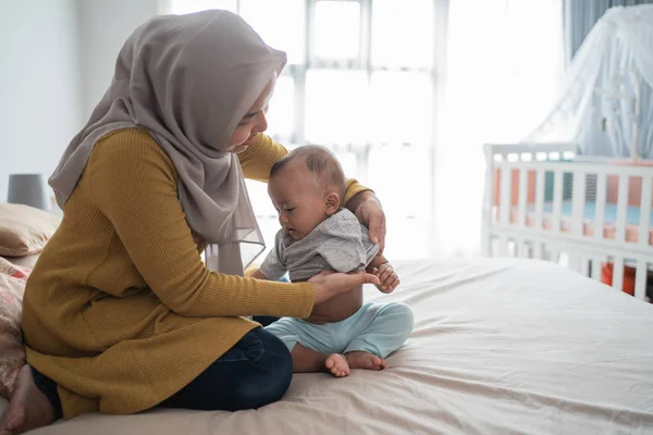 アジア系ムスリムは赤ちゃんの男の子の服を変え — ストック写真