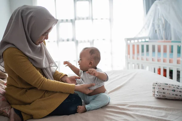 Asian muslim change her baby boy clothes — 스톡 사진