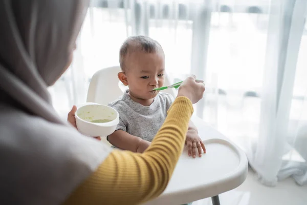 Asiatico bambino mangiare solido cibo da madre — Foto Stock