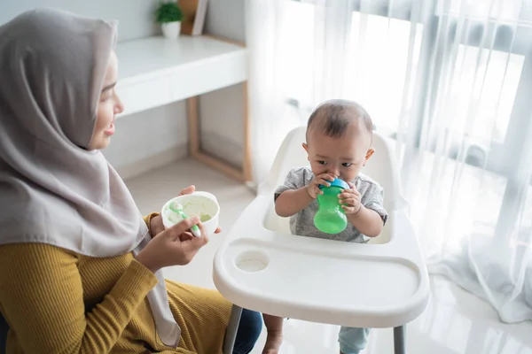 Asian child eating solid food from mother — 스톡 사진