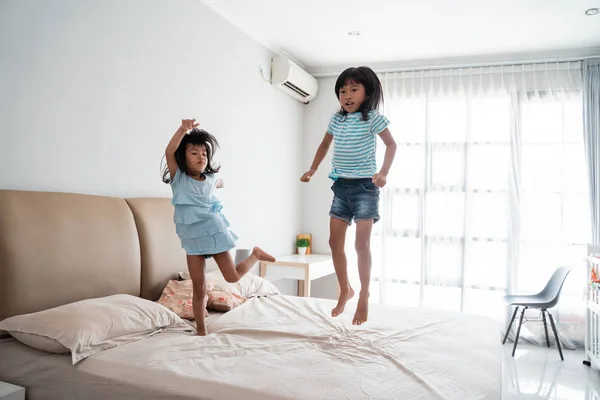 Irmã garoto se divertindo pulando na cama — Fotografia de Stock
