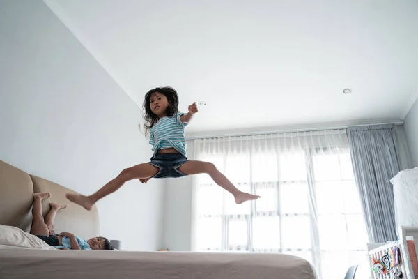 Jumping young kid on the bed — 图库照片