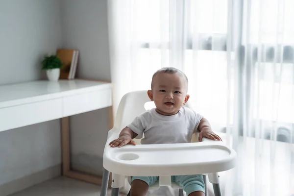 Asiático bebé niño sentado en alto silla —  Fotos de Stock