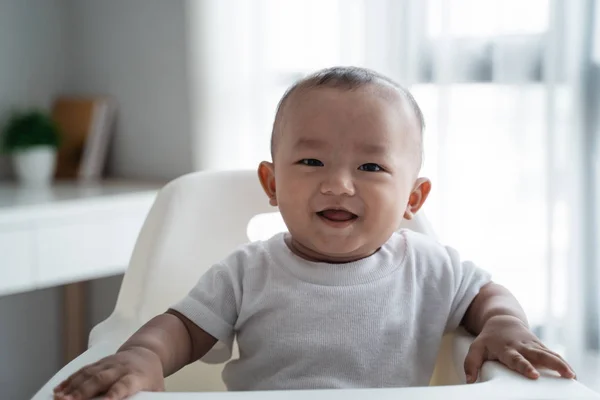 亚洲男婴坐在高高的椅子上 — 图库照片