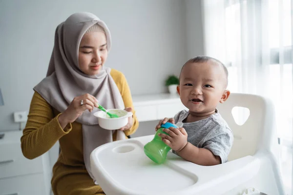 Asian Mother feeding her baby son with spoon — 스톡 사진
