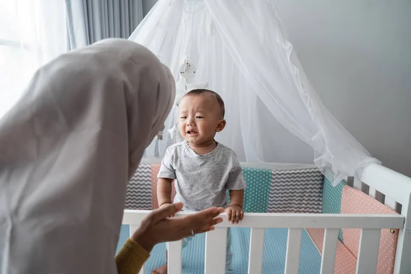 母亲设法在婴儿床前安慰哭泣的孩子 — 图库照片