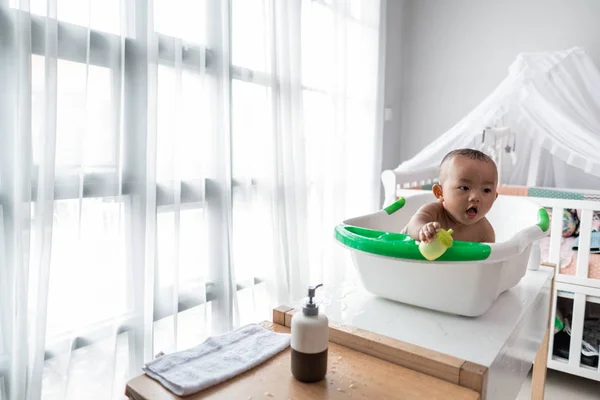 Niño tomando un baño sentado en un lavabo —  Fotos de Stock