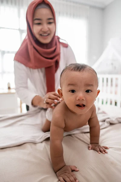 Madre aplicando aceite de bebé a su bebé —  Fotos de Stock