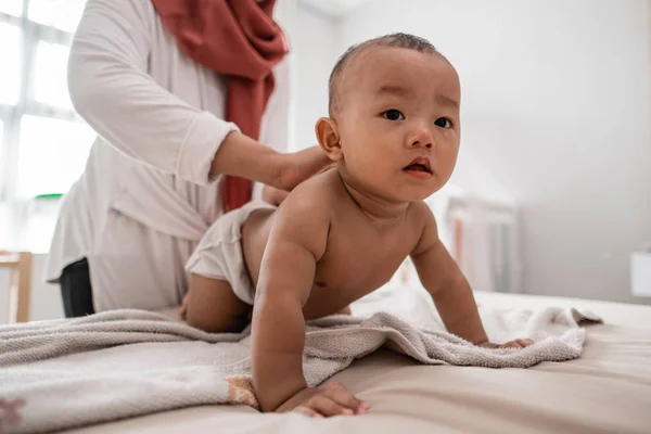 Mother applying baby oil to her baby — Stock Photo, Image