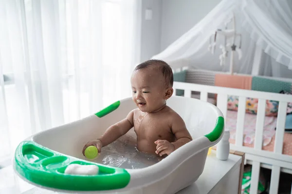 Хлопчик малюк насолоджується грою з водою, приймаючи ванну — стокове фото