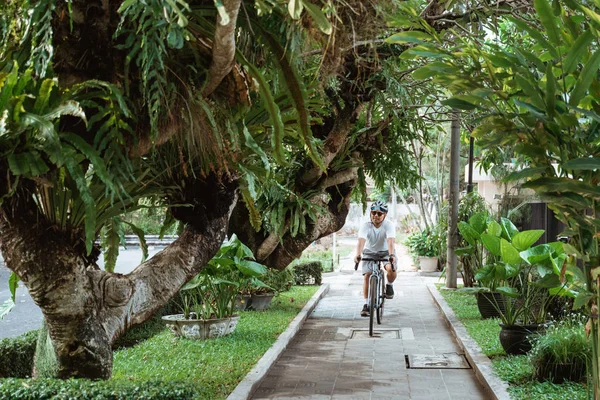 Hombre joven que usa cascos de bicicleta al montar en bicicleta —  Fotos de Stock