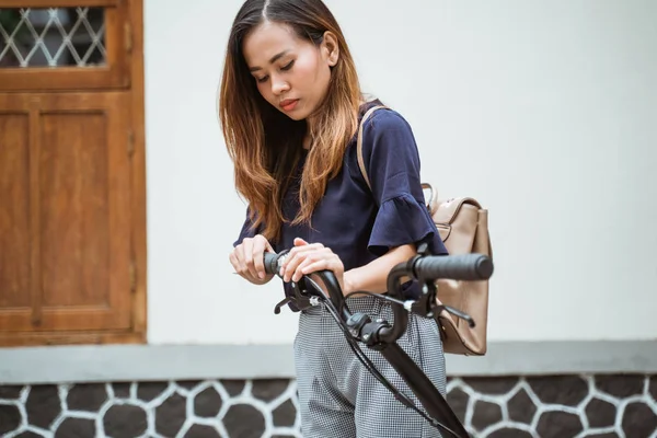 Ázsiai fiatal nő kipróbálás fold neki összecsukható kerékpár felkészülni menni dolgozni — Stock Fotó