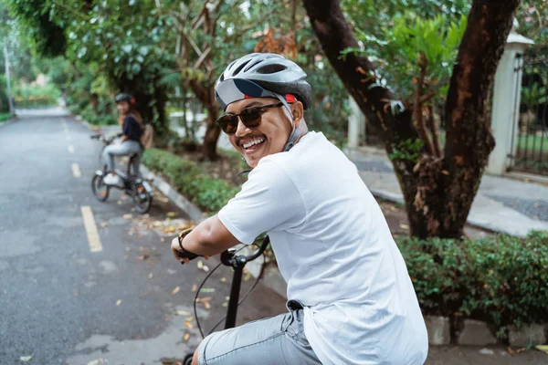 Asian youths look back and smiling when riding bicycles on the road — Stock Photo, Image