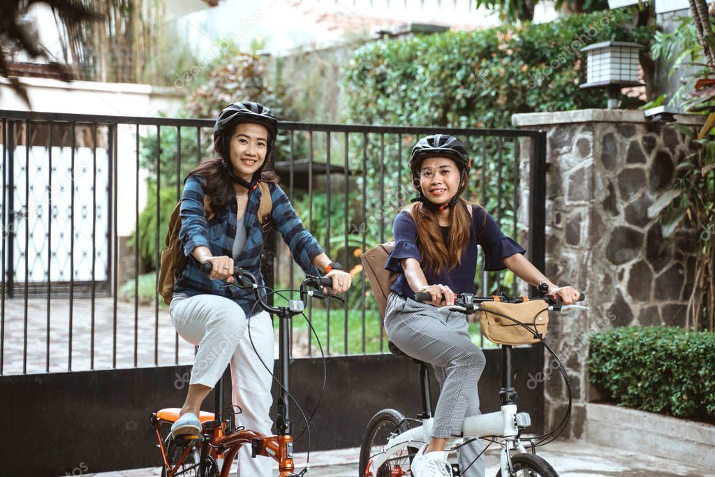 Two asian young woman wearing helmet and bags ready go to campus