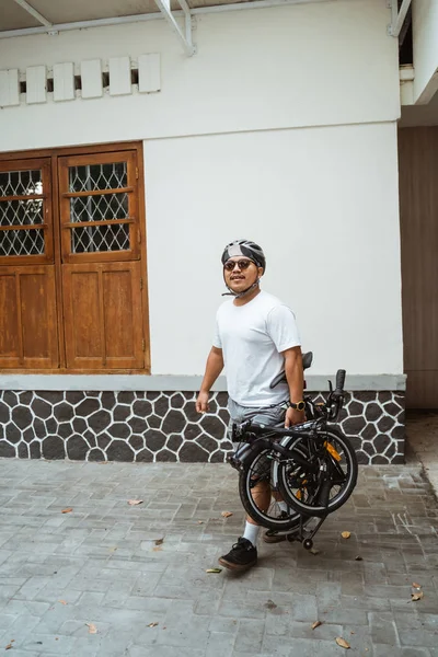 Ázsiai férfi napszemüveg tartja a összecsukható kerékpár, hogy készen áll a munkába — Stock Fotó