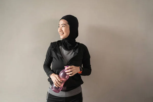 Hijab sporty asiático damas usando sportswear celebrar un botella —  Fotos de Stock