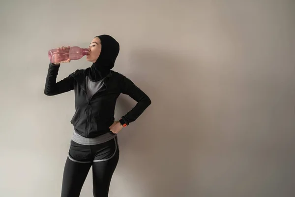 Asiatische muslimische Frauen tragen beim Trinken von Wasserflaschen Hijab-Sportbekleidung — Stockfoto