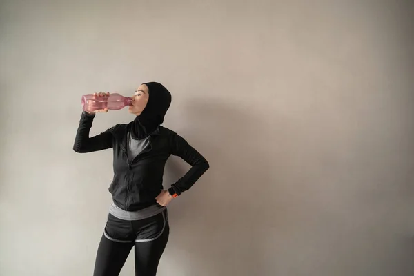 Türbanlı sporcu Asyalı kadınlar su şişeleri içerken spor giyiyorlar. — Stok fotoğraf