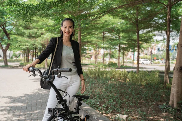 Femme asiatique jeune travailleur debout avec son vélo pliant — Photo