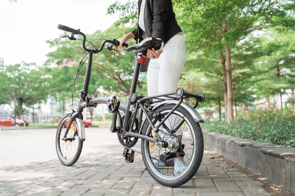 Mujer asiática trabajador sosteniendo su bicicleta plegable — Foto de Stock