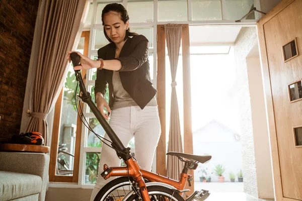 Joven empresaria prepara una bicicleta plegable desde su casa — Foto de Stock