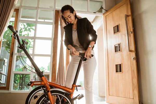 Joven empresaria prepara una bicicleta plegable desde su casa —  Fotos de Stock