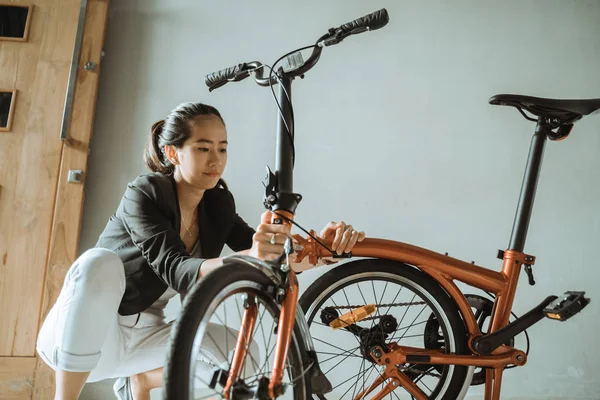 Mujer asiática prepara una bicicleta plegable de su casa para ir a trabajar — Foto de Stock
