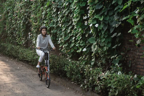 Las mujeres asiáticas usan cascos para montar bicicletas plegables —  Fotos de Stock