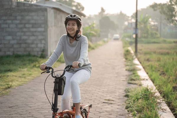Asijské ženy nosí helmy jezdit skládací kola — Stock fotografie