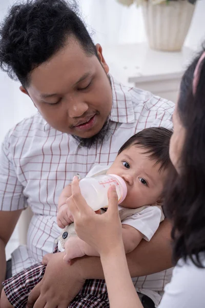 Moeder voeden zoon met melk in baby fles — Stockfoto