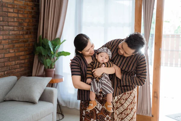 Asiatische Familie trägt javanische Batik mit schläfrigem kleinen Sohn — Stockfoto