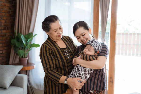 Heureux grand-mère et mère en portant petit fils endormi — Photo