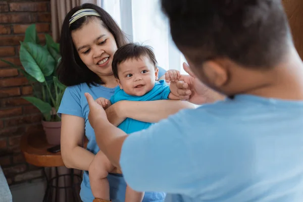 Asiático familia vistiendo azul camisa con bromeando a poco hijo —  Fotos de Stock